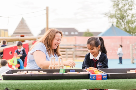 Teacher with a student in the playground